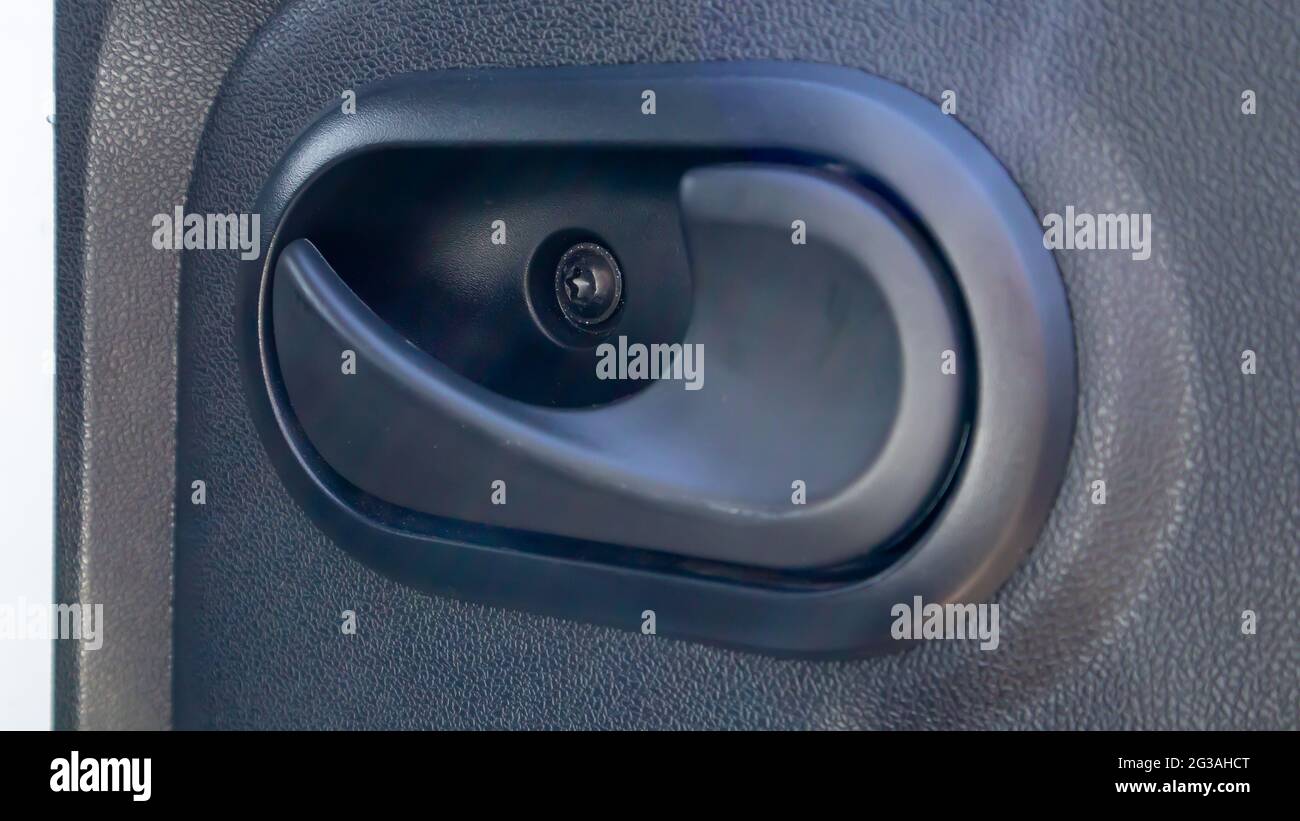 L'auto è all'interno. Chiusura della maniglia della porta dell'auto, all'interno della porta dell'auto. Maniglia interna in plastica della portiera per auto Foto Stock