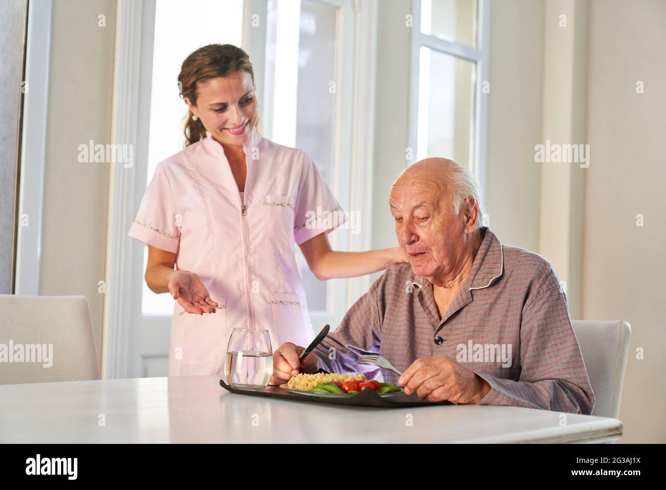 Senior ottiene la consegna a casa dei pasti su ruote dal servizio di consegna Foto Stock