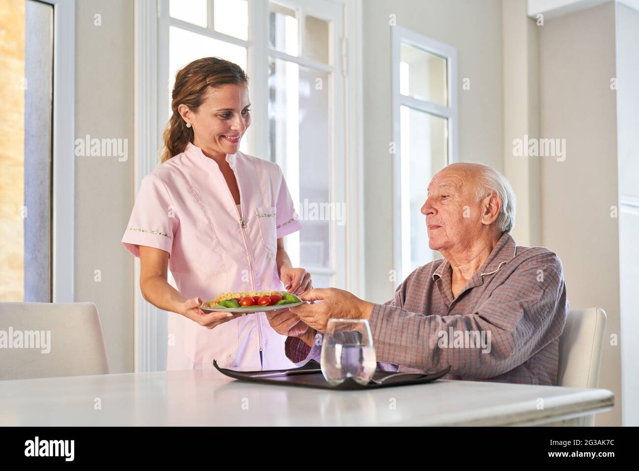 Gli anziani vengono serviti per pranzo o cena dal servizio di consegna presso la residenza degli anziani Foto Stock