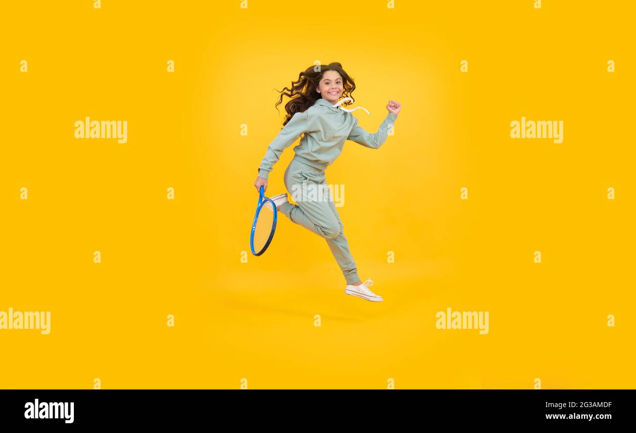bambino energico con racchetta da tennis. ragazza teen corre all'allenamento. dedicato al fitness Foto Stock