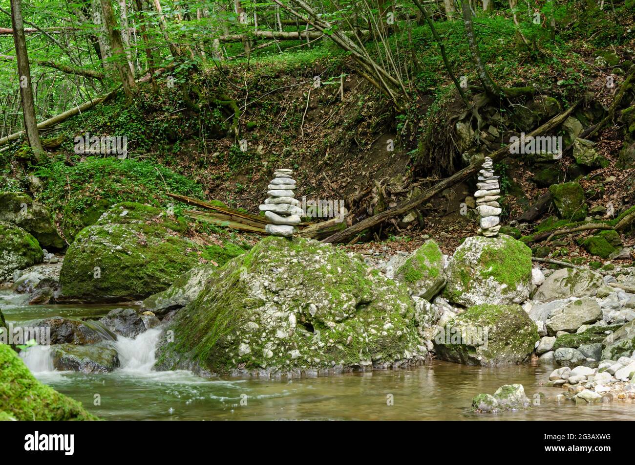 Due pile di roccia in uno streambed. Pali di rocce impilate, che si bilanciano su grandi rocce in un letto di un ruscello selvaggio. Rocce posate piatte l'una sull'altra. Foto Stock