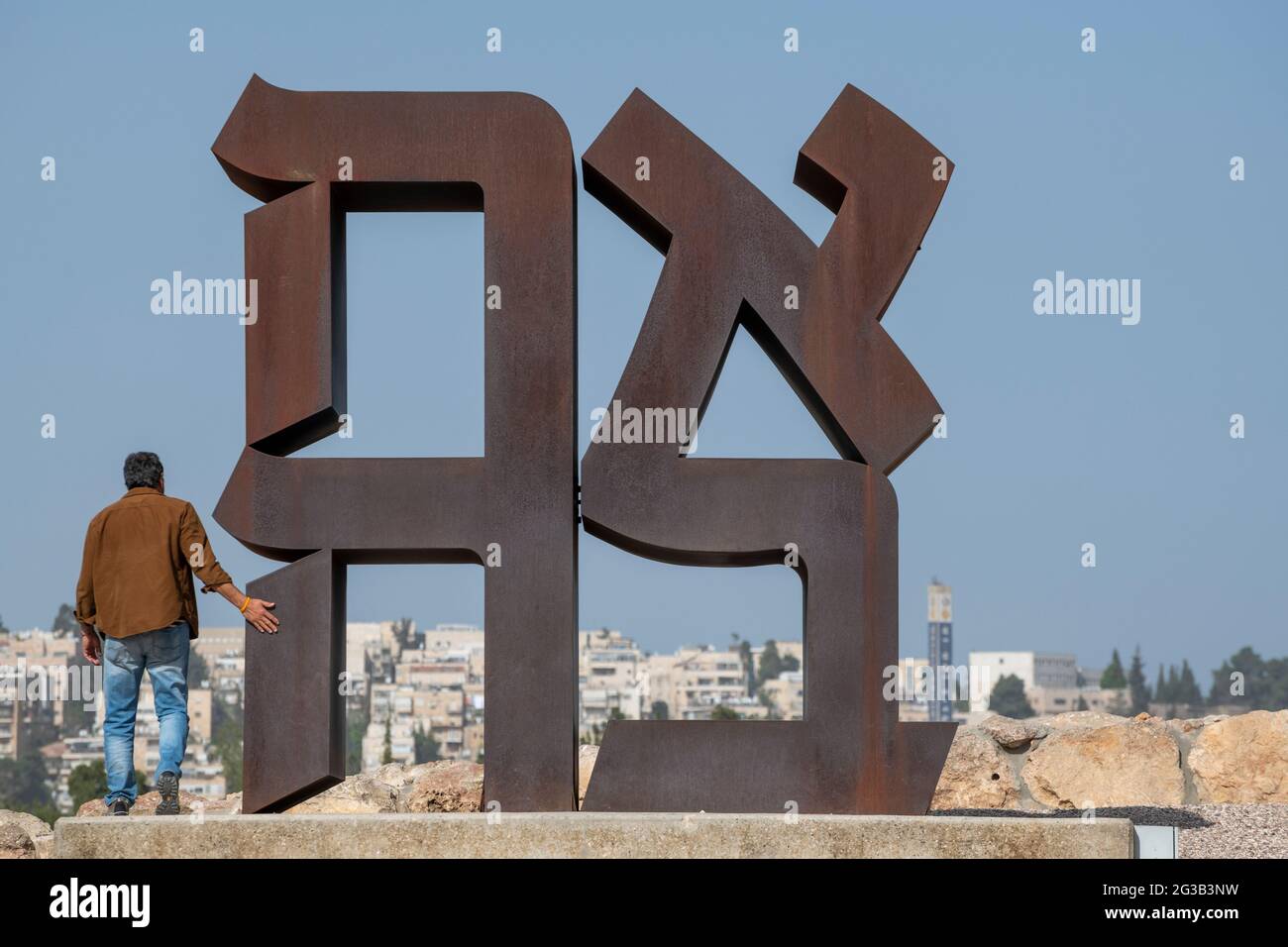 Visitatore israeliano che esplora il famoso AHAVA (amore in ebraico), Cor-ten scultura in acciaio alta 12 metri di Robert Indiana al Museo di Israele. Gerusalemme Foto Stock