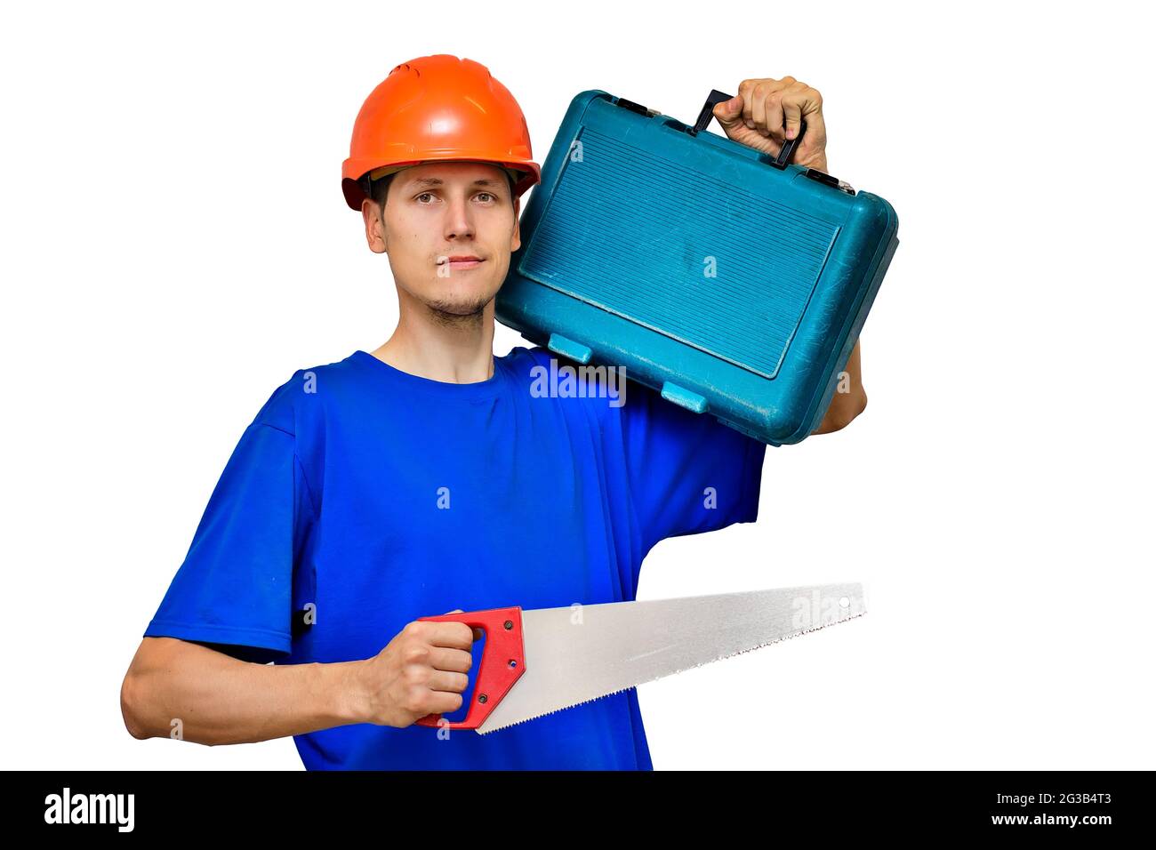 Ritratto di un giovane costruttore su uno sfondo chiaro. Un lavoratore in un casco da costruzione tiene un seghetto e una valigia con gli attrezzi nelle sue mani. Layout Foto Stock