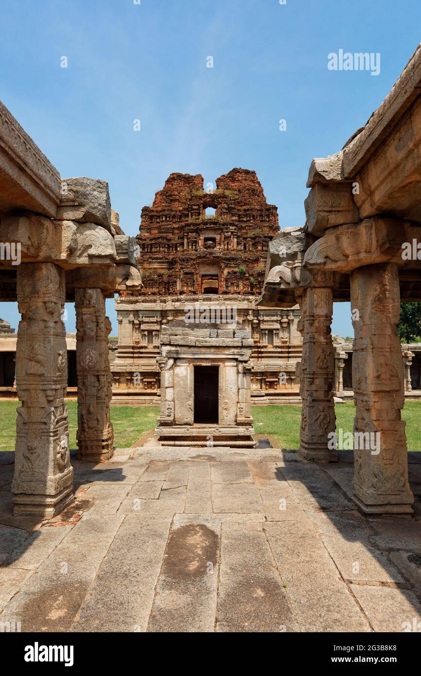 Sala all'aperto con colonne Mandapa e torre di gopura nel tempio di Achyutaraya ad Hampi Foto Stock
