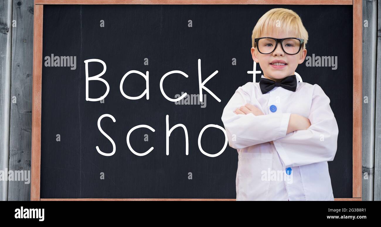 Composizione di un ragazzo sorridente che torna a scuola su un testo bianco sulla lavagna Foto Stock