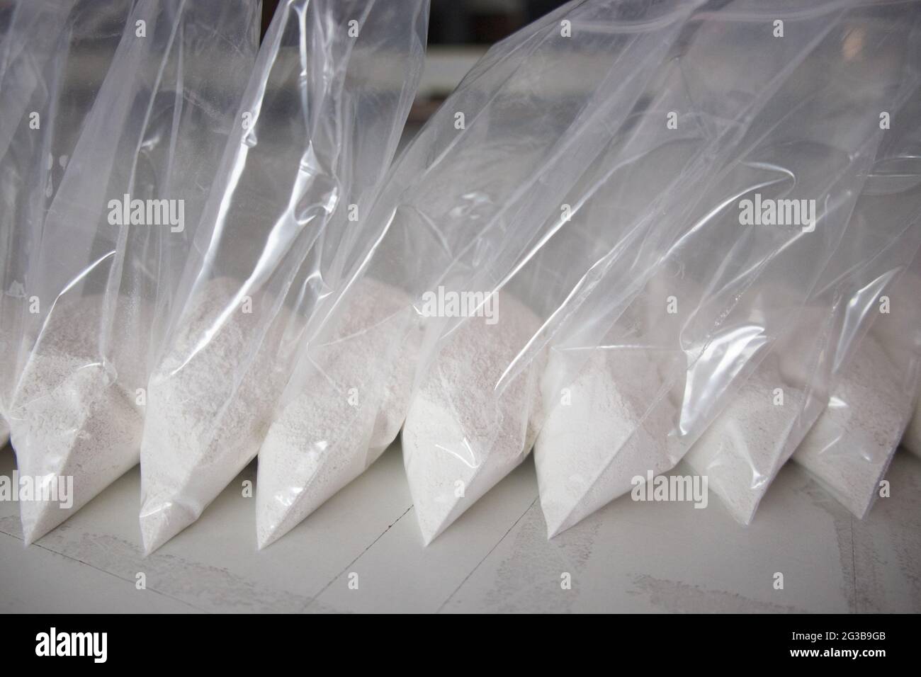 Un gran numero di bustine trasparenti riempite di polvere bianca. Polvere  bianca confezionata in bustine piccole Foto stock - Alamy