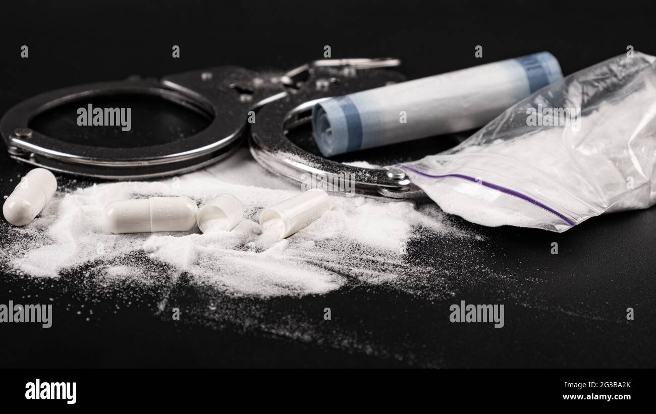 punizione di droga, manette e polvere bianca di cocaina Foto Stock
