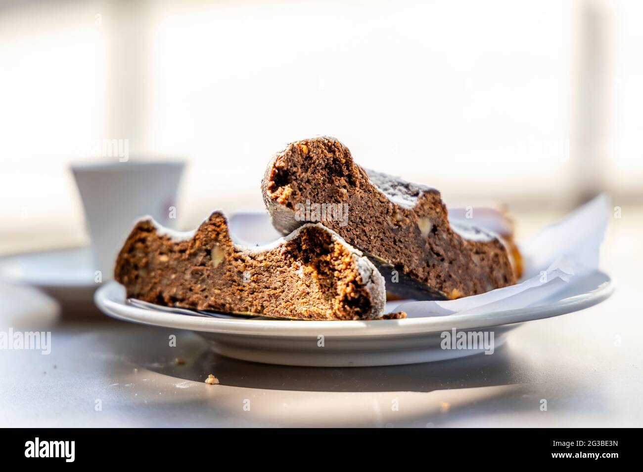 Dessert portoghese a base di farina di mais e miele chiamato Broa de mel con caffè sullo sfondo, Portogallo Foto Stock