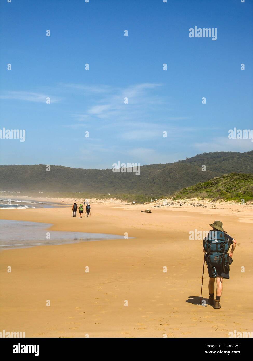 Escursionisti su una spiaggia di sabbia dorata e tranquilla a Natures Valley, nella sezione Tsitsikamma del parco nazionale percorso giardino in Sud Africa Foto Stock