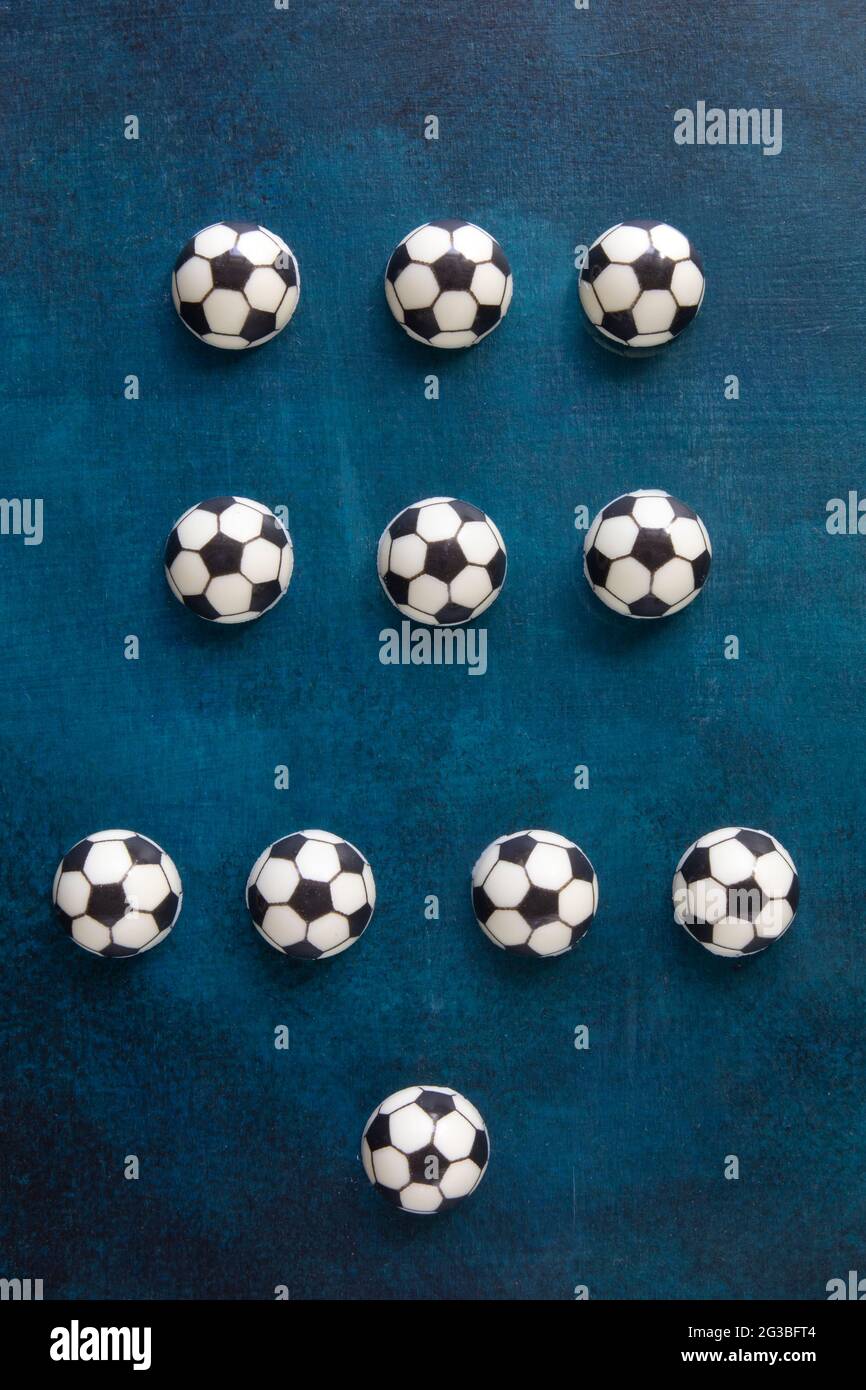 Lo schema più popolare di giocatori di calcio posizioni sul campo (4-3-3) da torte al cioccolato sotto forma di palloni da calcio su un bel tavolo blu - t Foto Stock