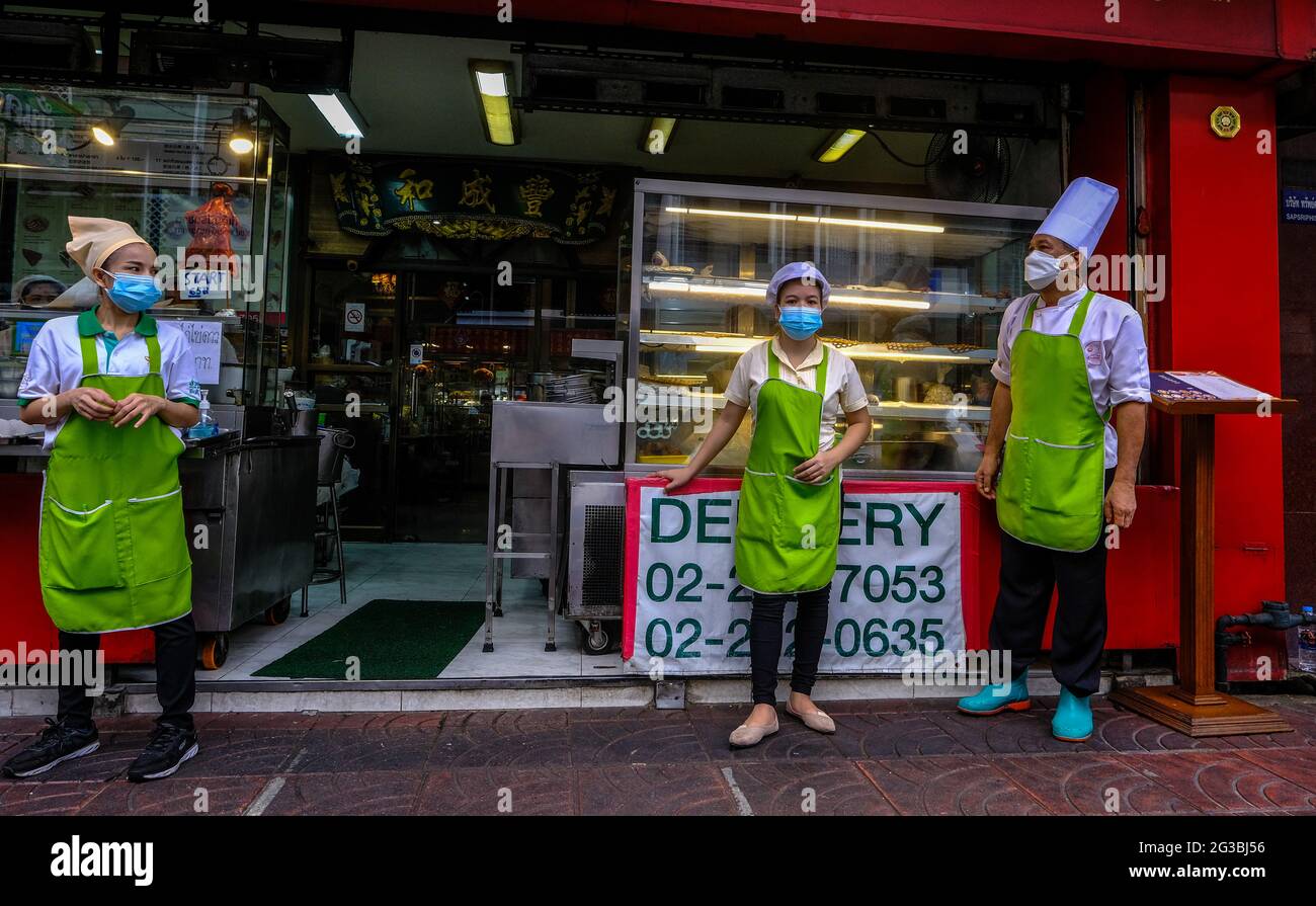 I lavoratori dei ristoranti si trovano fuori dai loro locali a Chinatown, Bangkok, Thailandia Foto Stock