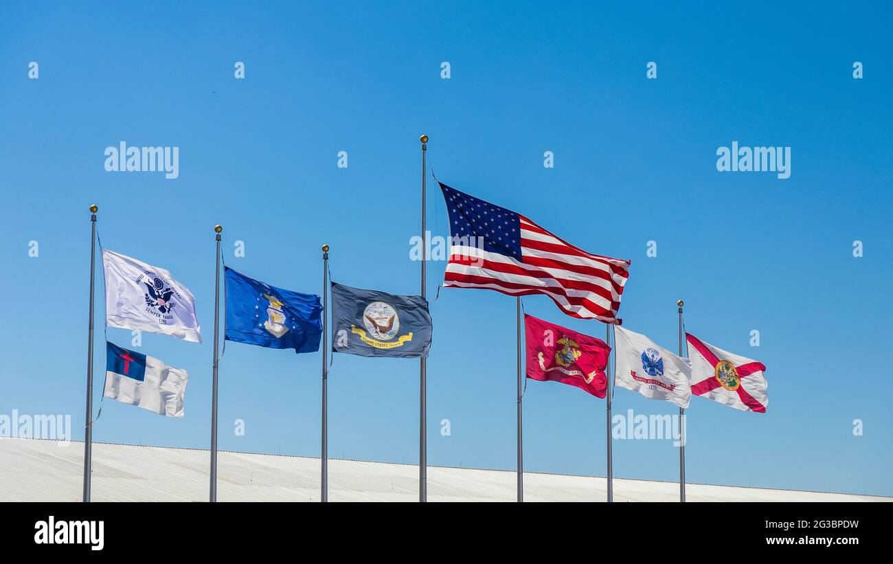 Bandiera degli Stati Uniti, bandiera dello stato della Florida, bandiera cristiana e bandiera delle forze armate volano in giornata di sole con cielo blu. Foto Stock