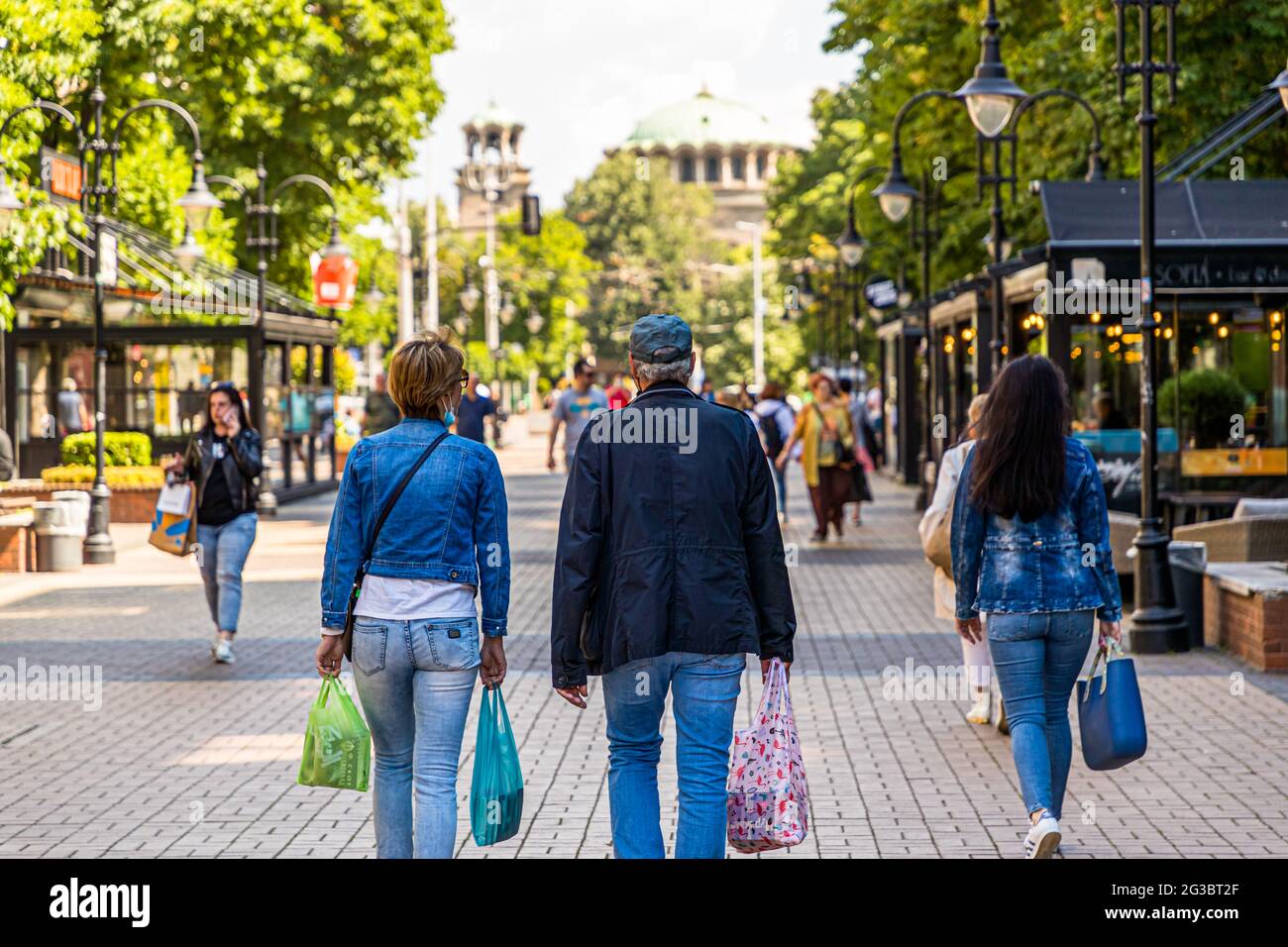 Passers-by con borse per lo shopping in una zona pedonale di Sofia, Bulgaria Foto Stock