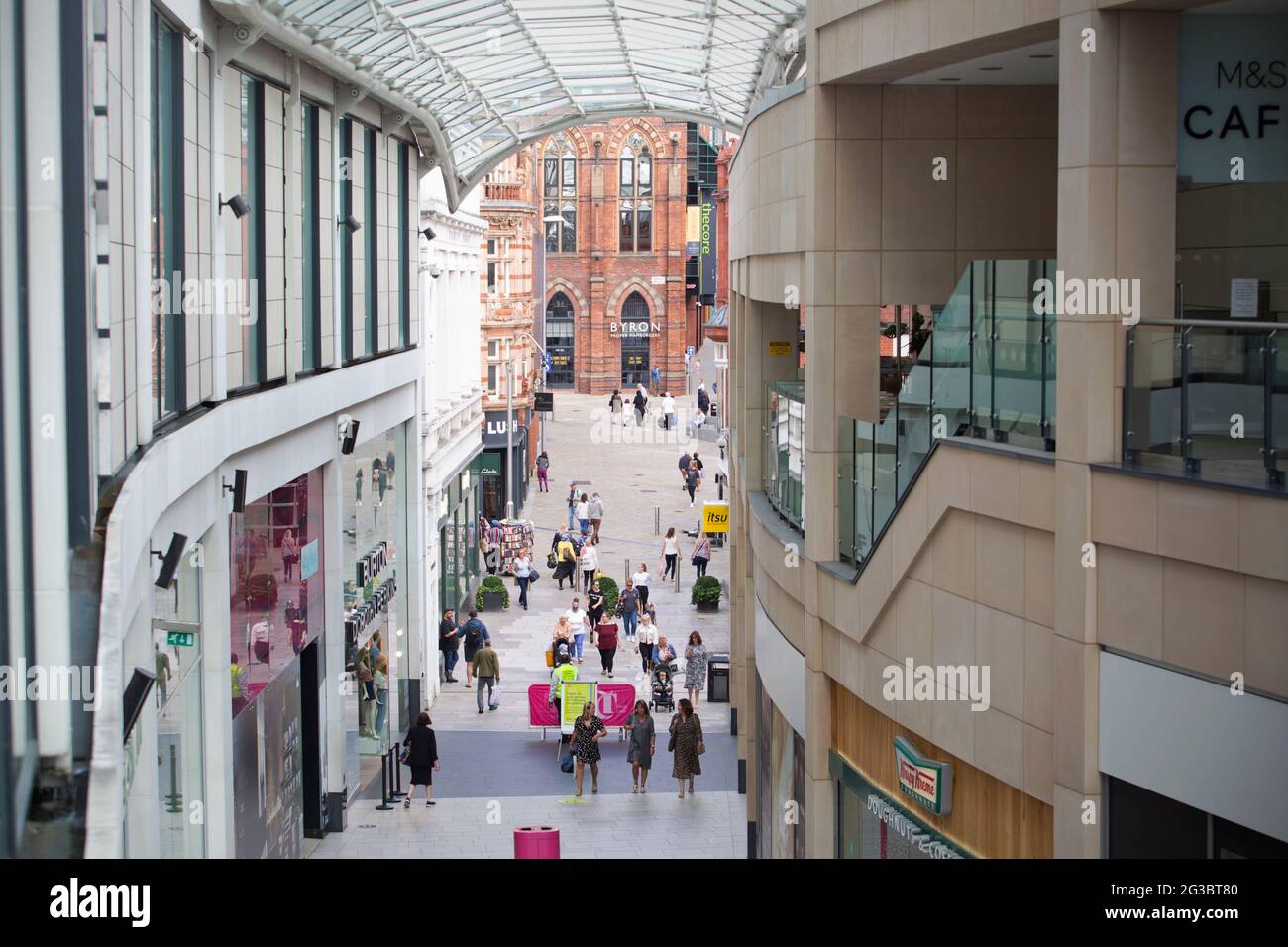 Persone che camminano attraverso l'area dello shopping del centro di Leeds. Leeds è un centro città che ancora non sta ritornando alla vita normale dopo-lockdown con t Foto Stock