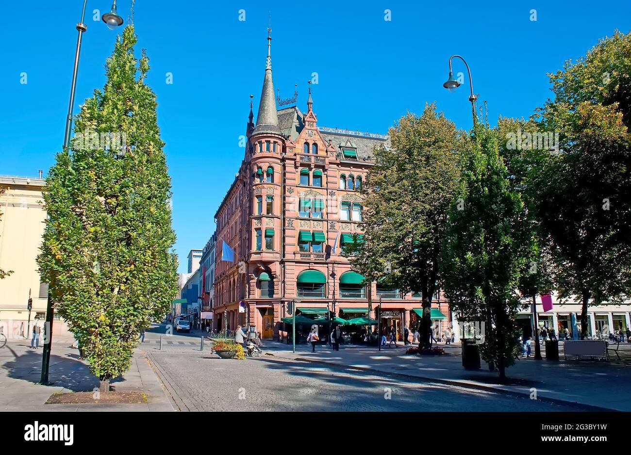 Osserva gli splendidi edifici storici di Karl Johans Gate Street dalla piazza Eidsvolls, con gli alti alberi sparsi, Oslo, Norvegia Foto Stock