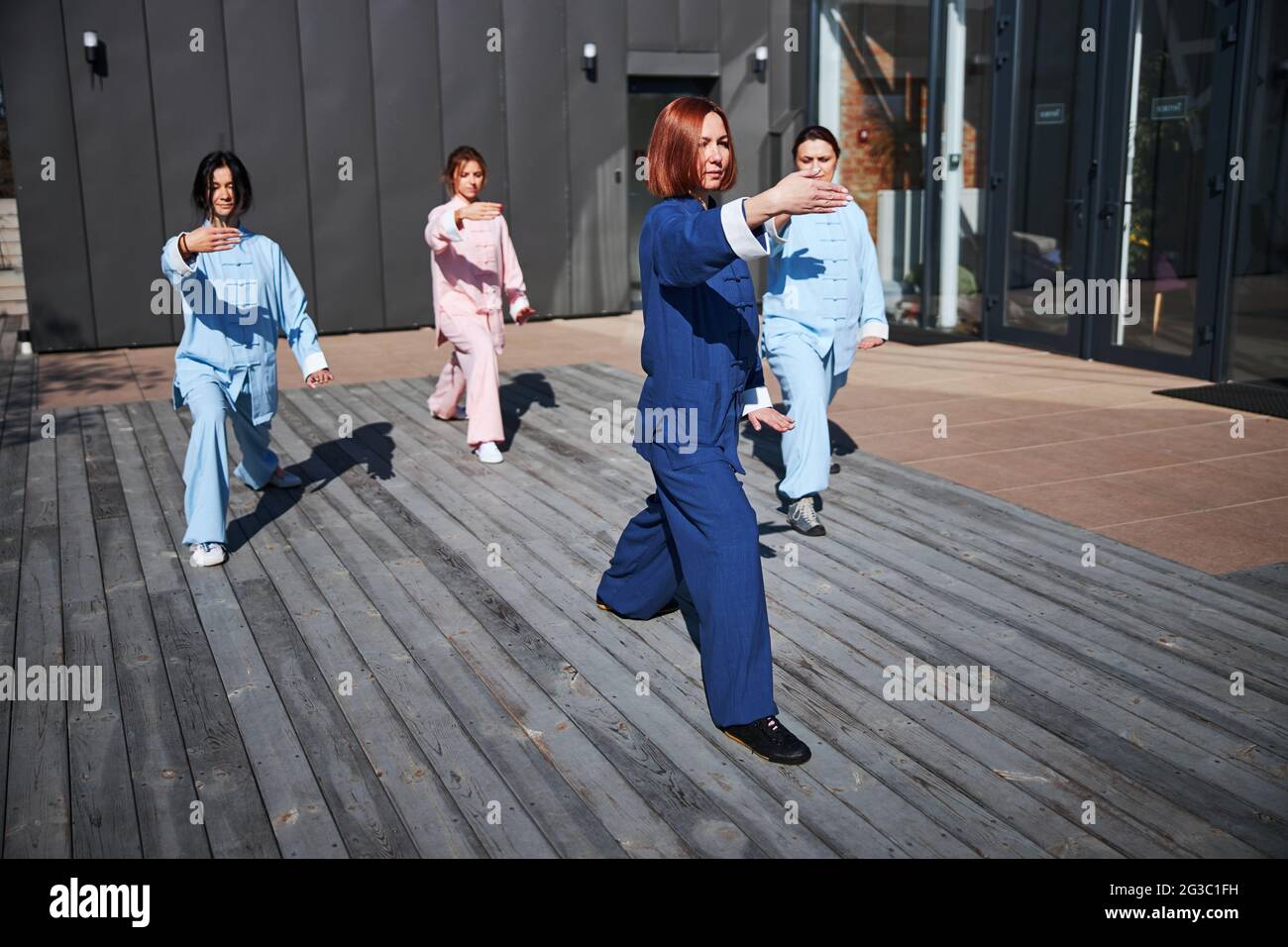 Giovani donne fiduciose che lavorano con i tai chi Foto Stock