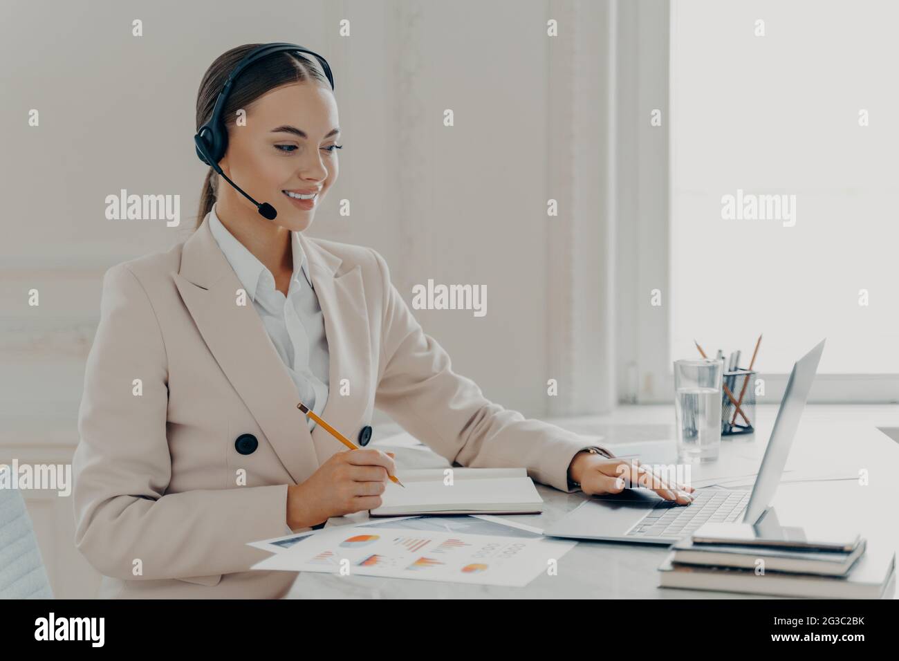 L'operatore del call center indossa le cuffie per parlare con il cliente Foto Stock