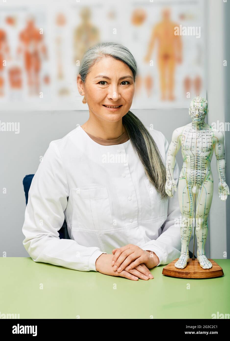 Agopuncturist donna matura, dottore della medicina tradizionale cinese sul suo posto di lavoro medico Foto Stock