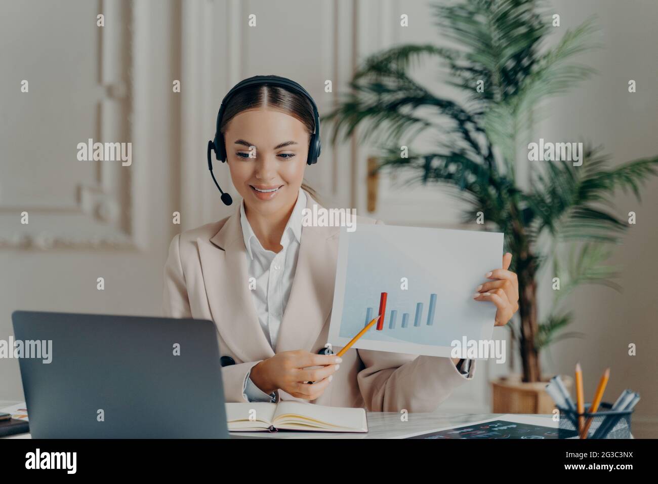 Economista femminile che ha una presentazione online mentre lavora in ufficio Foto Stock