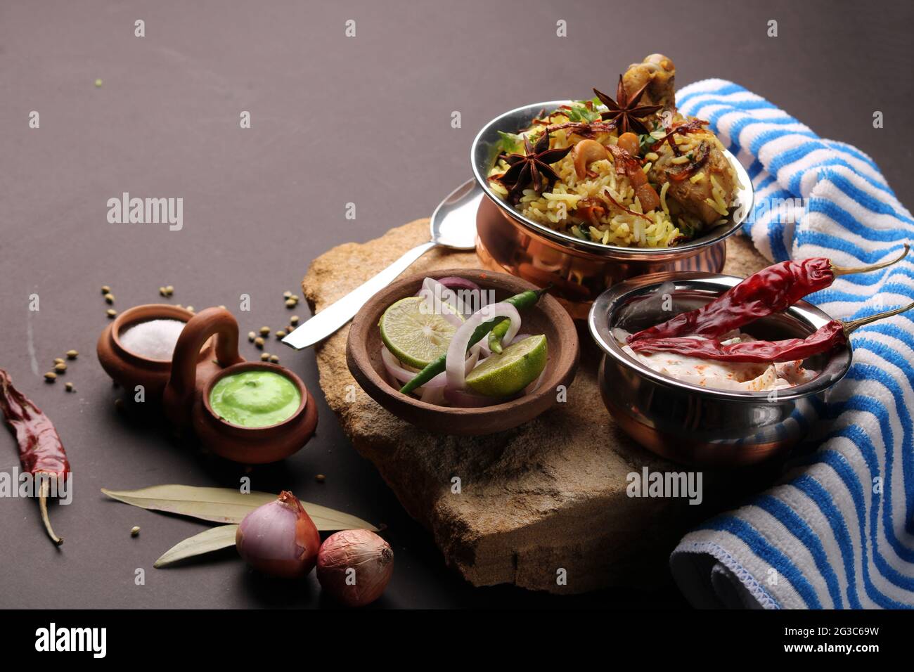 Pollo piccante dum biryani in tradizionale handi o creta pentola. Servito con raita di cipolla Foto Stock