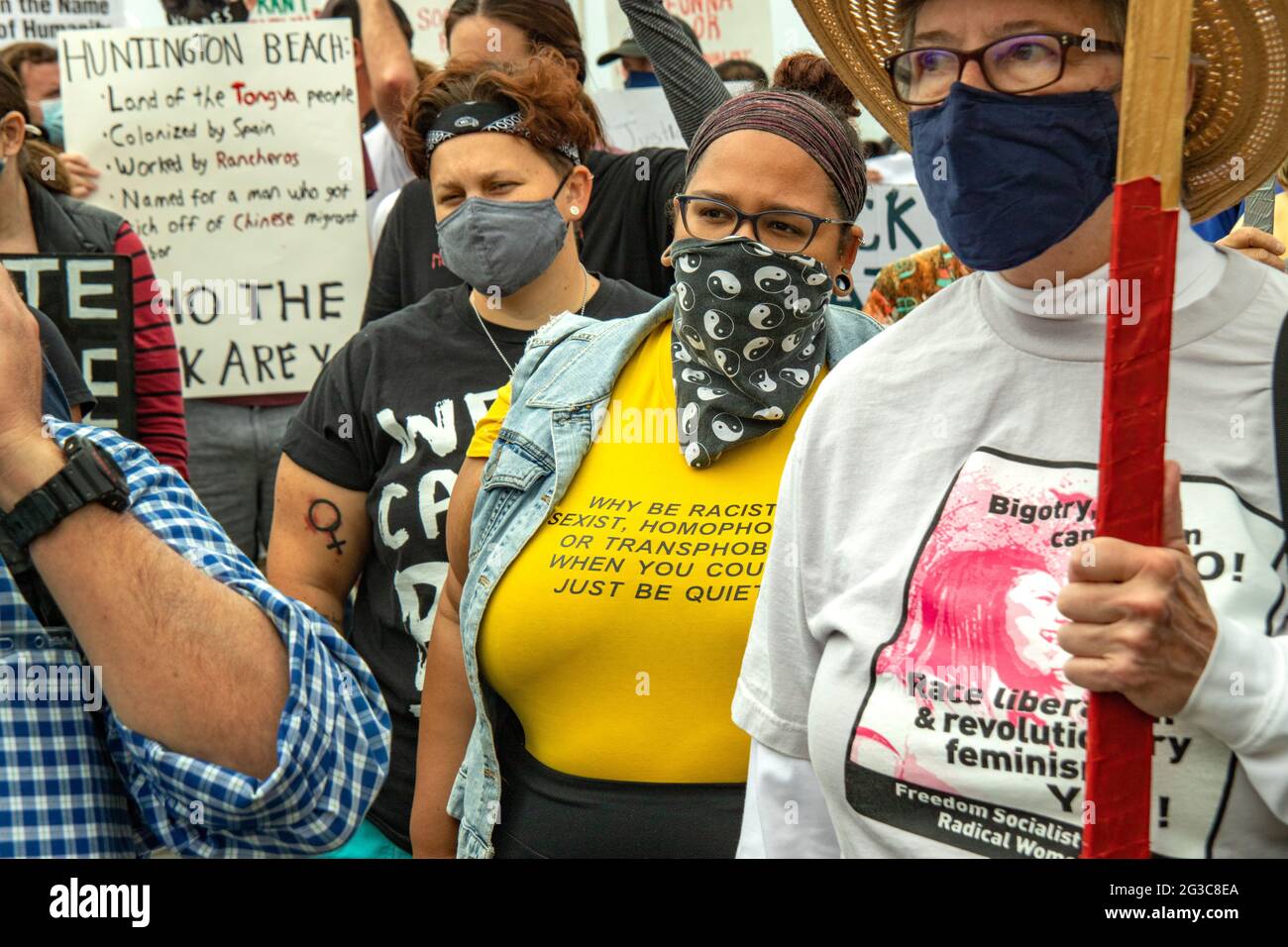 Mascherata contro la pandemia del coronavirus, una donna che manifesta a Huntington Beach, CA, esprime la sua opinione su altri manifestanti con un segno su di lui Foto Stock