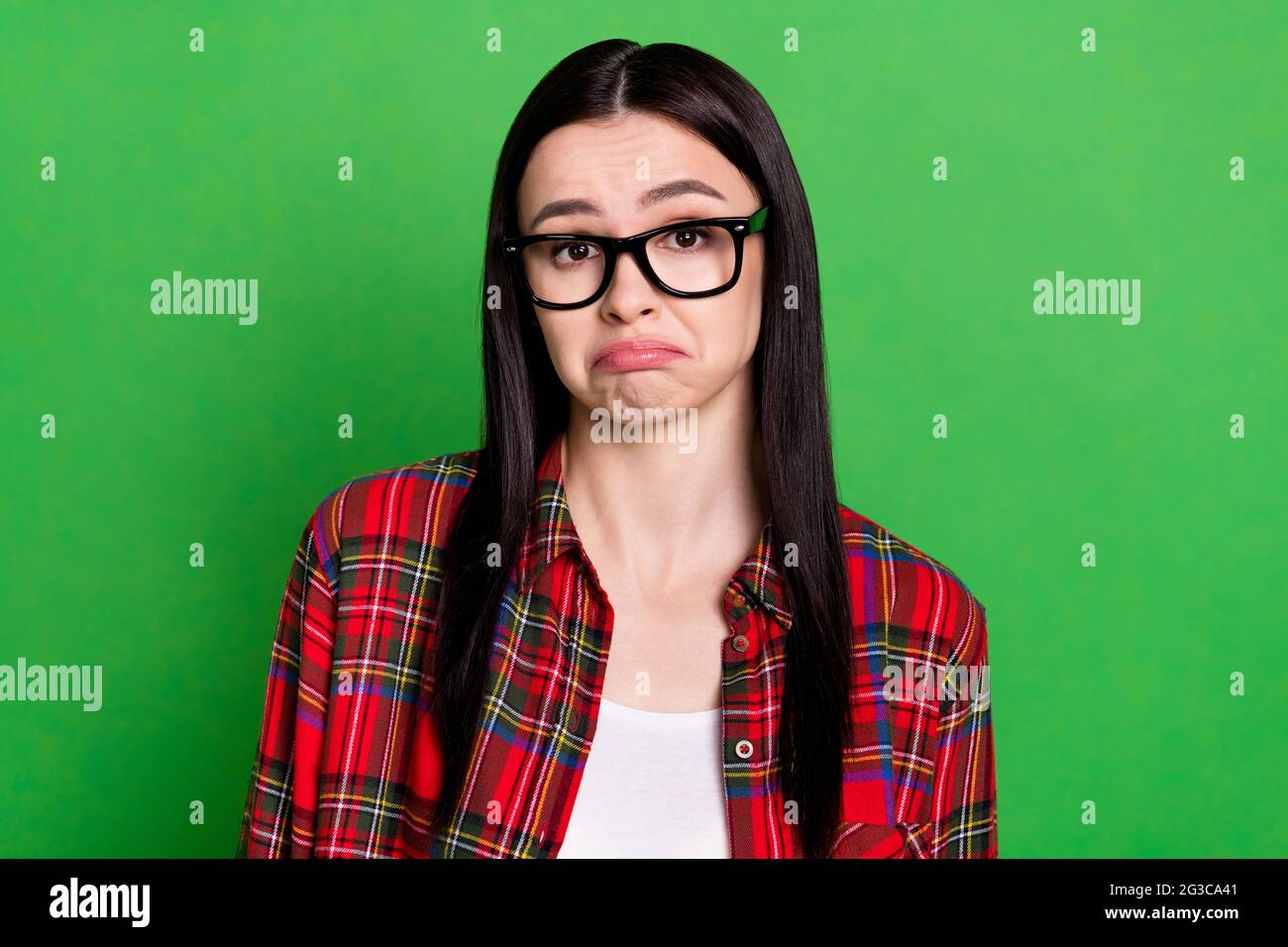 Foto di infelice donna dubbia indossare occhiali perplessi domanda isolata su sfondo di colore verde Foto Stock