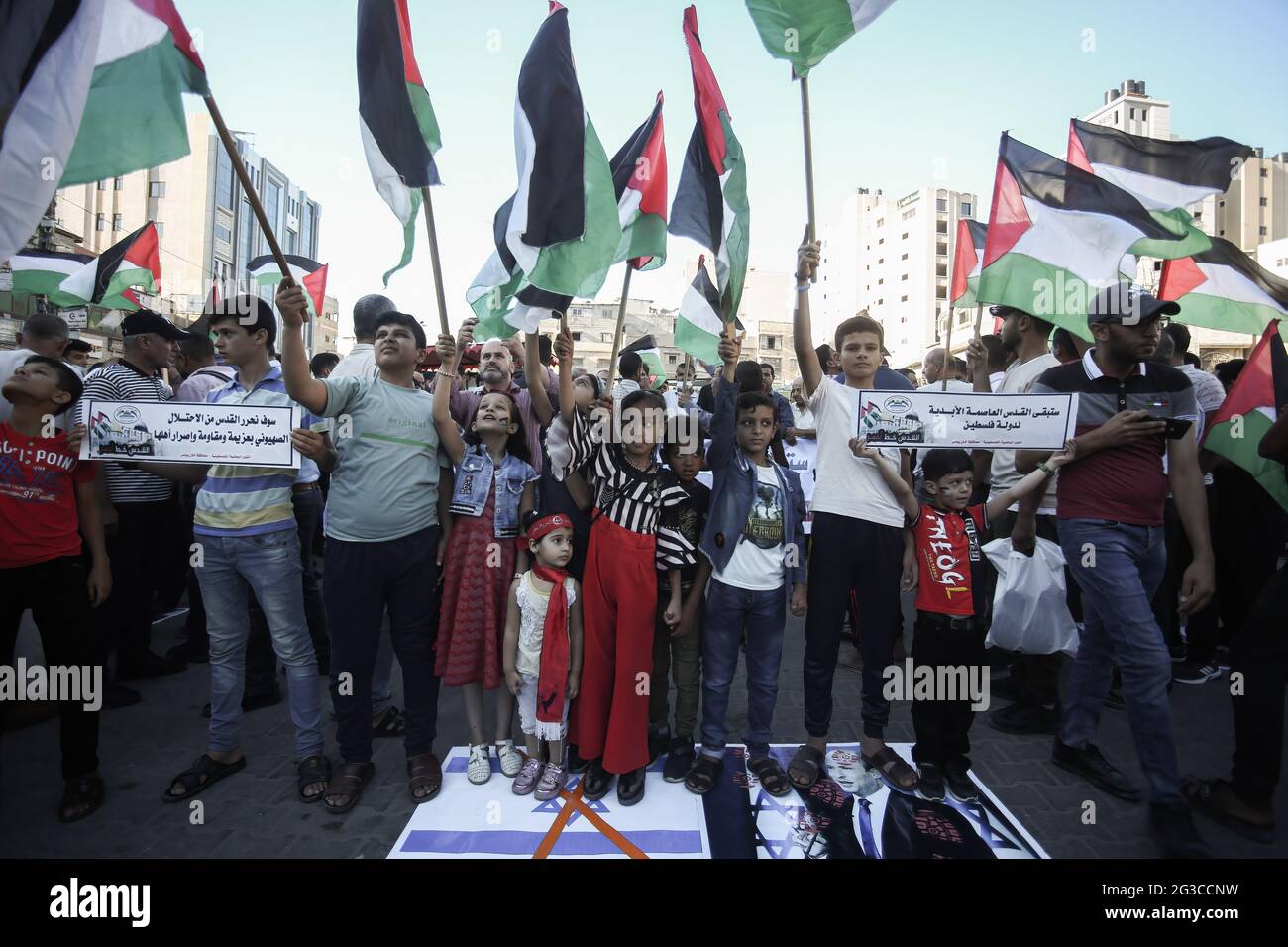 Gaza, Palestina. 15 giugno 2021. I manifestanti si sono impressi sul ritratto del primo ministro israeliano Naftali Bennett e della bandiera israeliana, durante una manifestazione nella striscia di Gaza meridionale, contro la "marcia della bandiera" organizzata dai coloni israeliani di estrema destra a Gerusalemme est. Credit: SOPA Images Limited/Alamy Live News Foto Stock