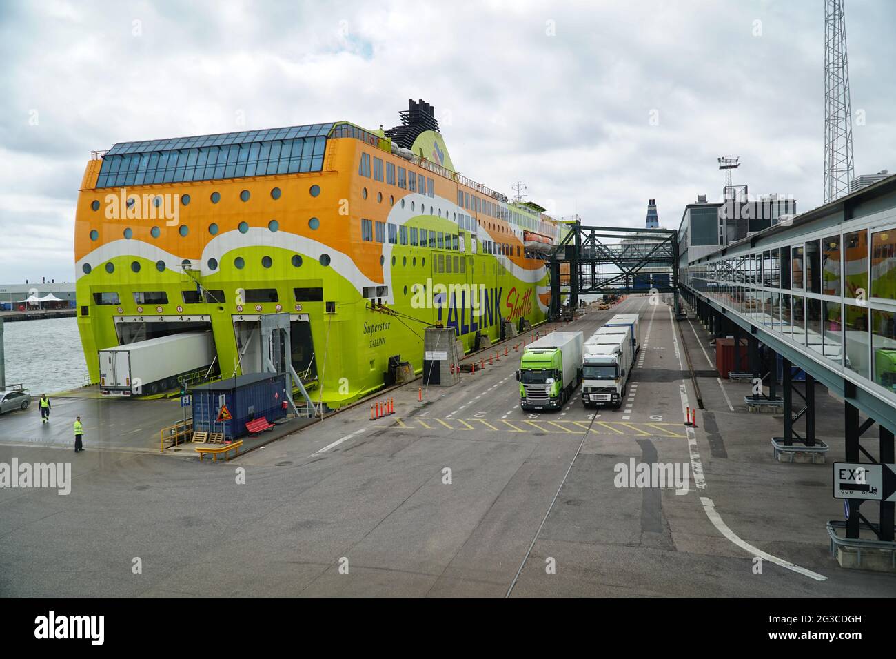 I camion nel terminal portuale aspettano l'ingresso del traghetto per auto. Nave RO Ro ormeggiata nel porto di Helsinki sul Mar Baltico, Finlandia, Europa. Foto Stock