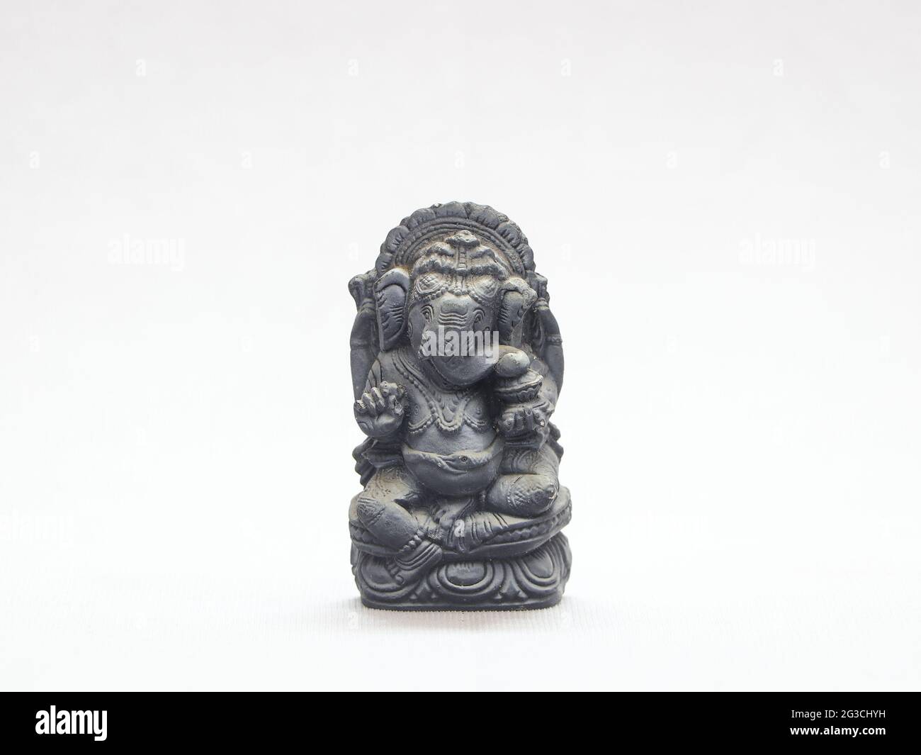 Primo piano di una piccola scultura rupestre di Ganesha isolata su sfondo bianco Foto Stock