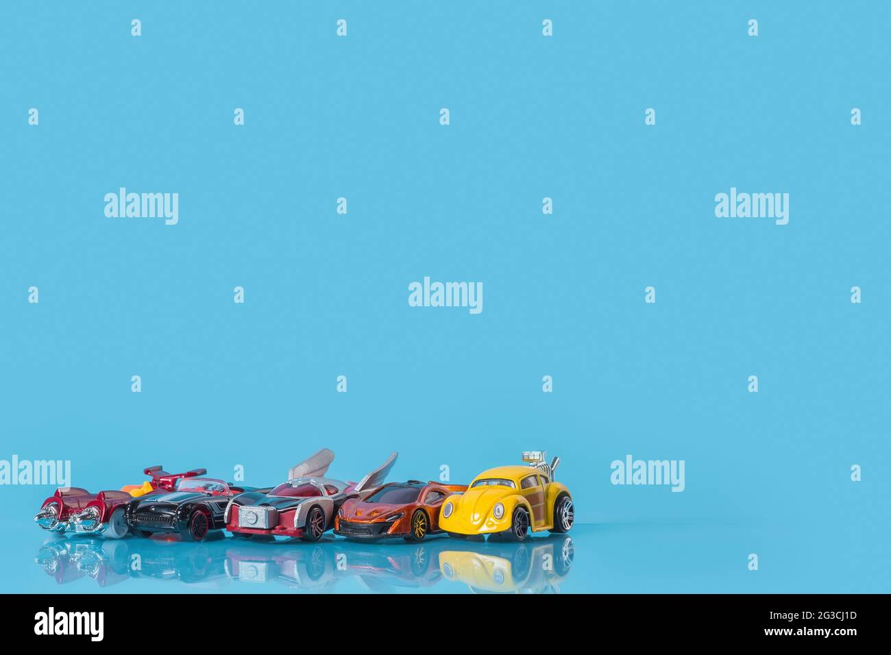 Molte auto giocattolo multicolore su sfondo blu, modelli di auto di piccole dimensioni Foto Stock