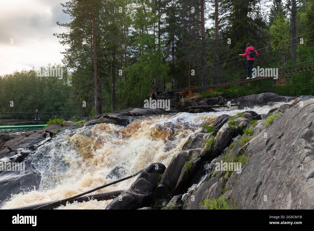Ruskeala, Russia - 11 giugno 2021: I turisti camminano sui ponti sospesi sopra le cascate naturali di Ruskeala. Il paesaggio estivo di Karelia Foto Stock