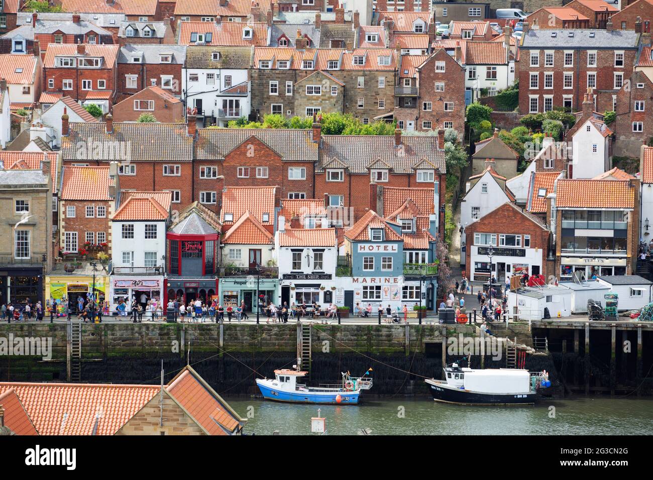Le persone si snodano lungo molti negozi, bar e ristoranti a Whitby, nel North Yorkshire, mentre sempre più persone scelgono di trascorrere una vacanza a casa propria Foto Stock