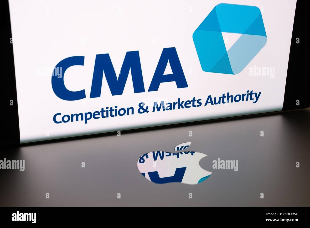 Logo Apple sulla superficie del macbook e logo del concorso CMA britannico e della Markets Authority sfocati visualizzati sullo schermo dello smartphone. Concetto. Stafford, Re Unito Foto Stock