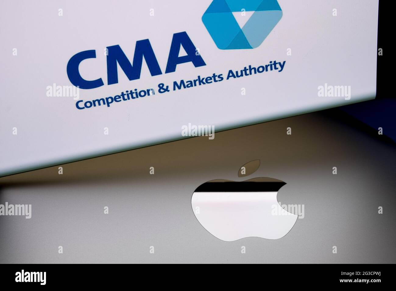 Logo Apple sulla superficie del macbook e logo del concorso CMA britannico e della Markets Authority sfocati visualizzati sullo schermo dello smartphone. Concetto. Stafford, Re Unito Foto Stock