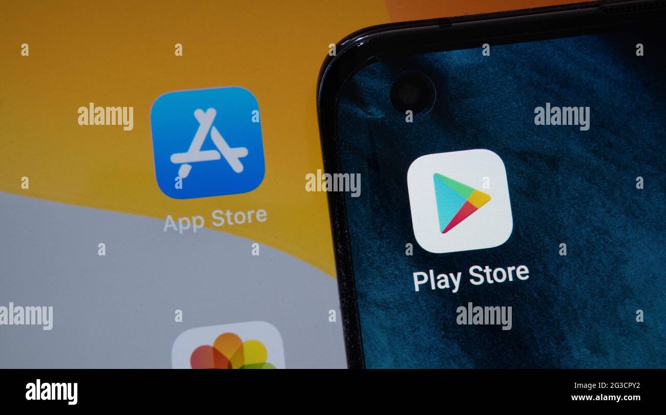 Google Play Store e app sfocate dell'App Store visualizzate sugli schermi di smartphone android e notebook Apple macbook M1. Concetto. Stafford, Regno Unito, 15 giugno 2021. Foto Stock