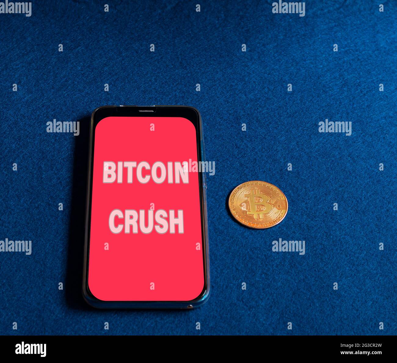 Moneta bitcoin oro accanto a uno smartphone Foto Stock