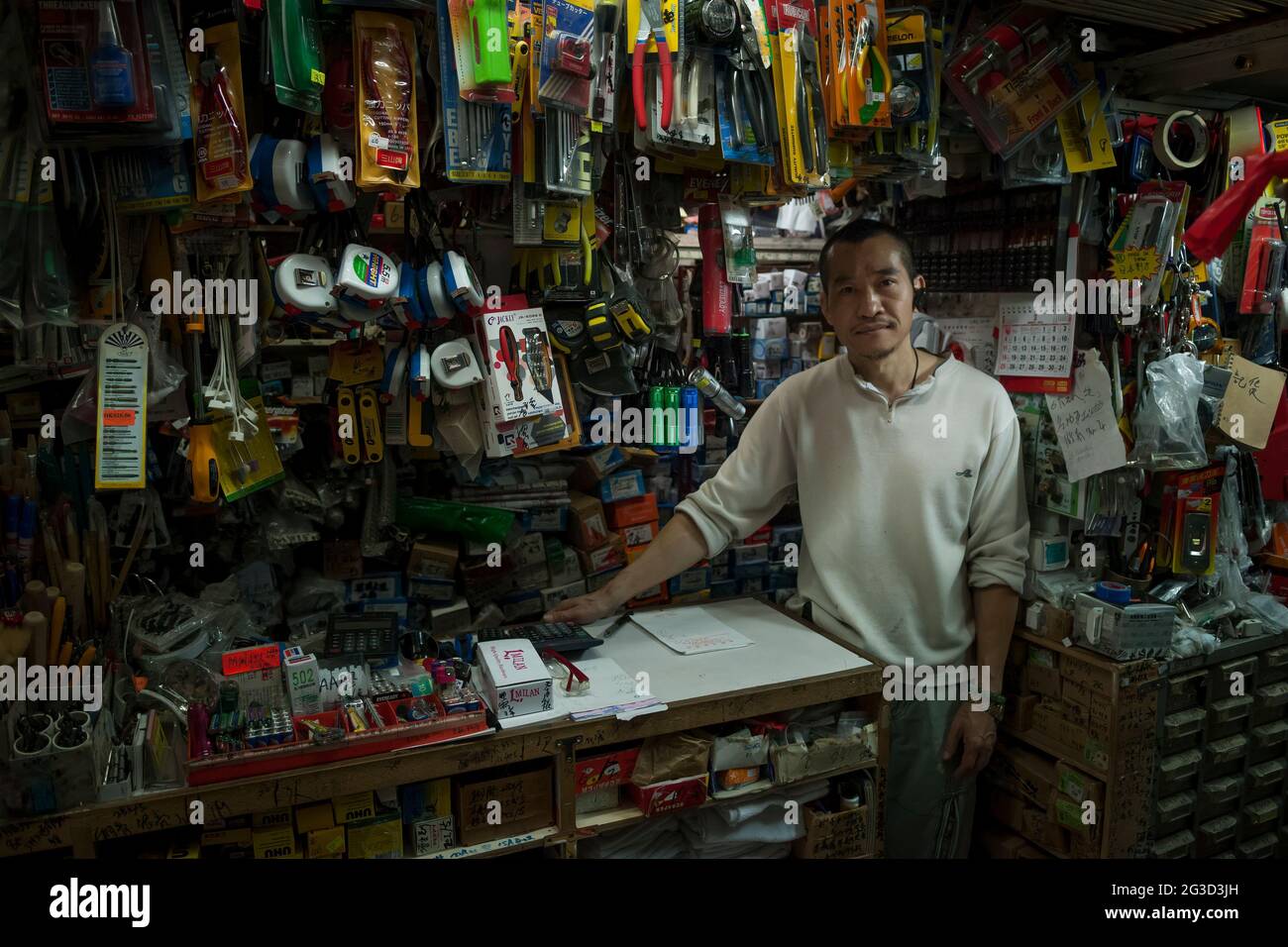 Il proprietario di un negozio di ferramenta tipicamente stretto e affollato, Wellington Street, Central, Hong Kong Island Foto Stock