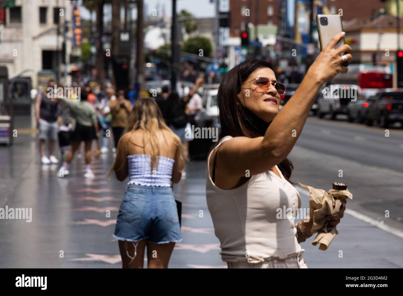 Los Angeles, Stati Uniti. 15 giugno 2021. Una donna prende un selfie lungo la Hollywood Walk of Fame vicino a Hollywood Blvd. E Highland Ave. Il 15 giugno 2021 a Los Angeles, CA. Martedì, la California ha revocato la maggior parte delle restrizioni COVID-19 e ha introdotto quella che è stata fatturata come la stateÕs "Grande riapertura". (Foto di Brian Feinzimer/Sipa USA) Credit: Sipa USA/Alamy Live News Foto Stock