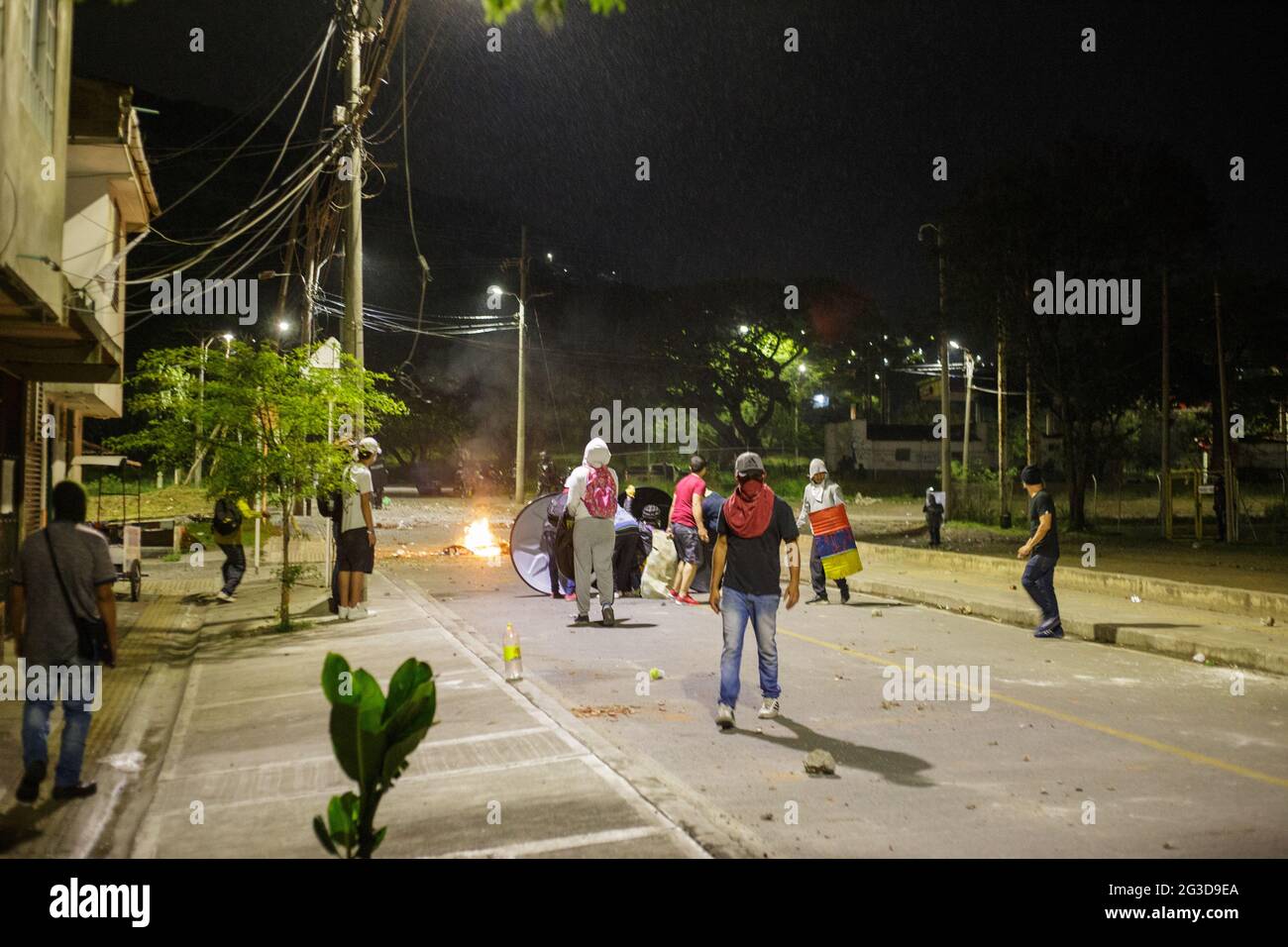 I membri della prima linea barricata e dimostrare come dimostranti e la polizia di rivolta della Colombia (ESMAD) si scontrano nella notte del 14 giugno 2021, a Yumbo - Cali, Valle del Cauca - Colombia, mentre le proteste anti-governative si svelano nella settima settimana contro il governo del presidente Ivan Duque, disordini e violenze che avevano causato almeno 70 morti. Foto Stock