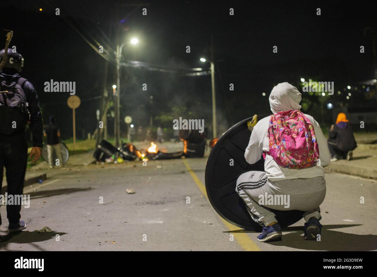 Manifestanti della guardia di prima linea da barattoli a gas lacrimogeni e granate stunt dietro diversi scudi artigianali come dimostranti e la polizia di rivolta della Colombia (ESMAD) scontro durante la notte del 14 giugno 2021, a Yumbo - Cali, Valle del Cauca - Colombia come le proteste anti-governative si svelano nella loro settima settimana contro il governo del presidente Ivan Duque, disordini e violenze che avevano causato almeno 70 morti. Foto Stock