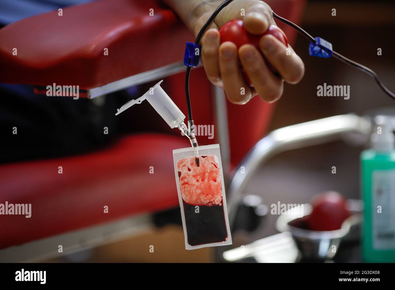 Profondità di campo poco profonda (fuoco selettivo) con la mano di un uomo che dona sangue. Foto Stock
