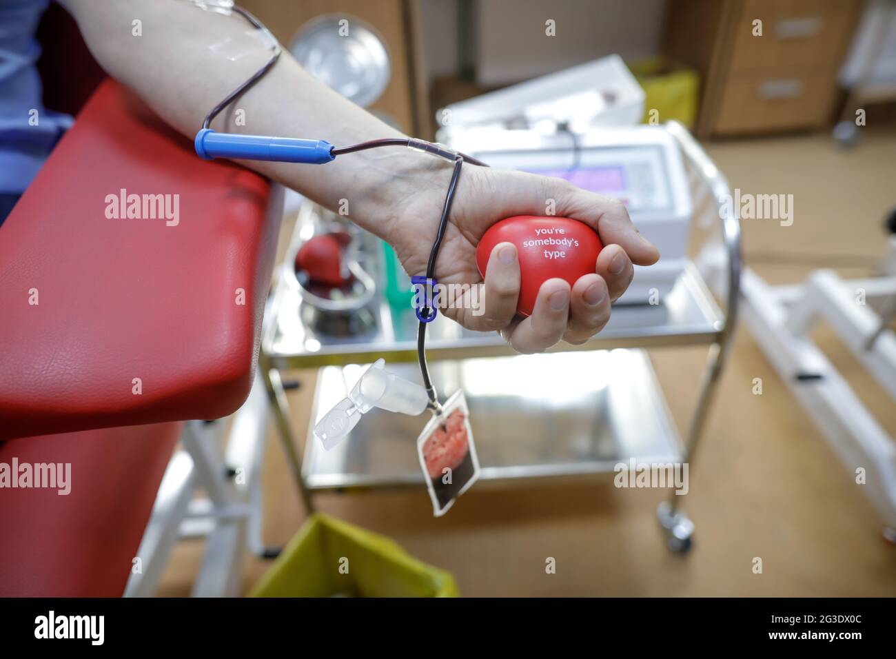 Profondità di campo poco profonda (fuoco selettivo) con la mano di un uomo che dona sangue. Foto Stock