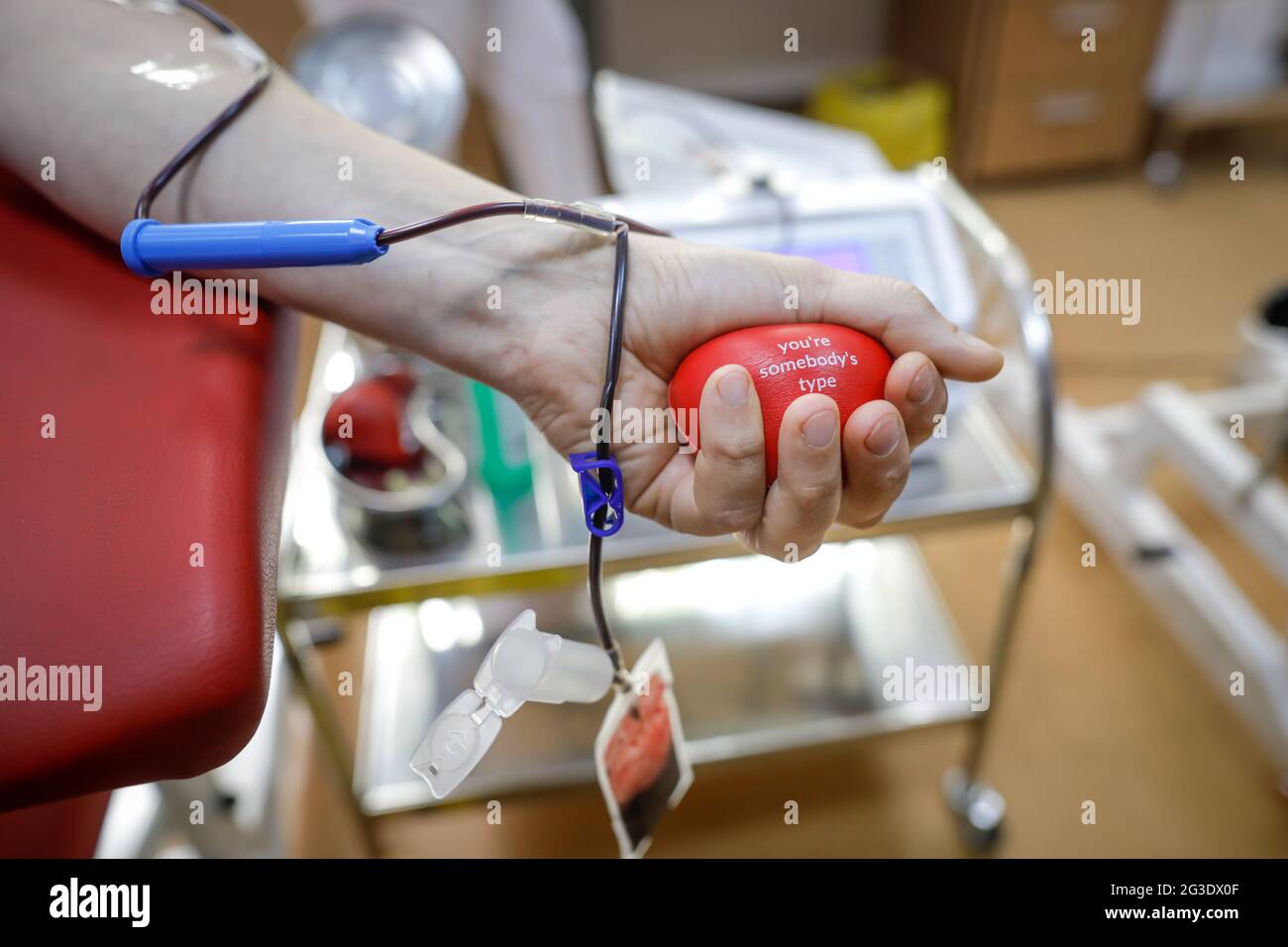 Profondità di campo poco profonda (fuoco selettivo) con la mano di un uomo che dona sangue. Foto Stock