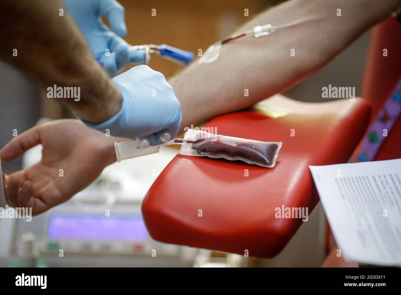 Profondità di campo poco profonda (fuoco selettivo) con le mani di un lavoratore medico che prepara un volontario per la donazione di sangue. Foto Stock