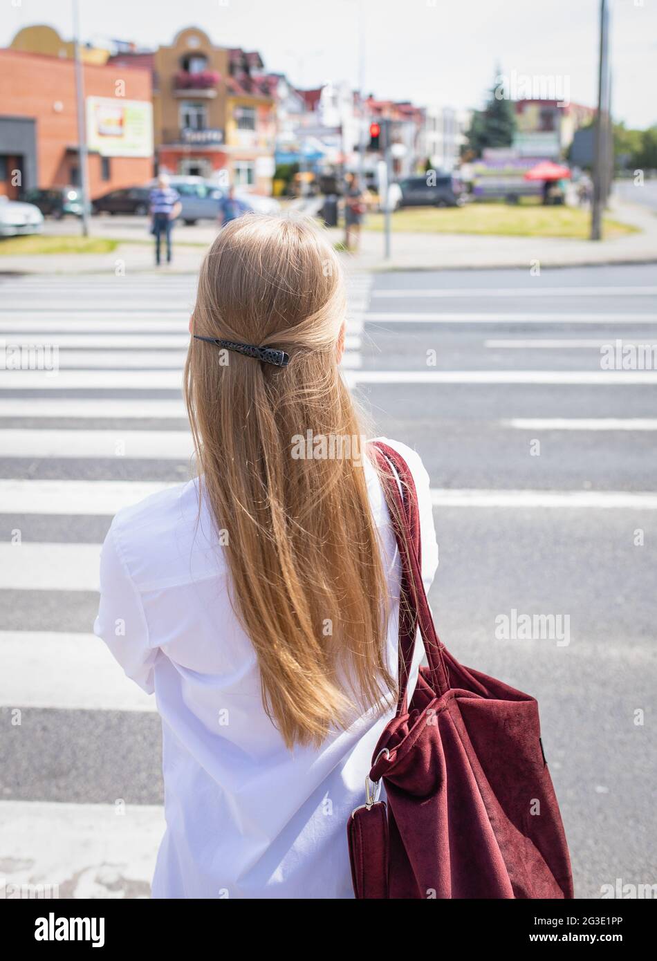 Gniezno, Polonia - ragazza di fronte ad un passaggio pedonale, in attesa di un semaforo verde. Foto Stock