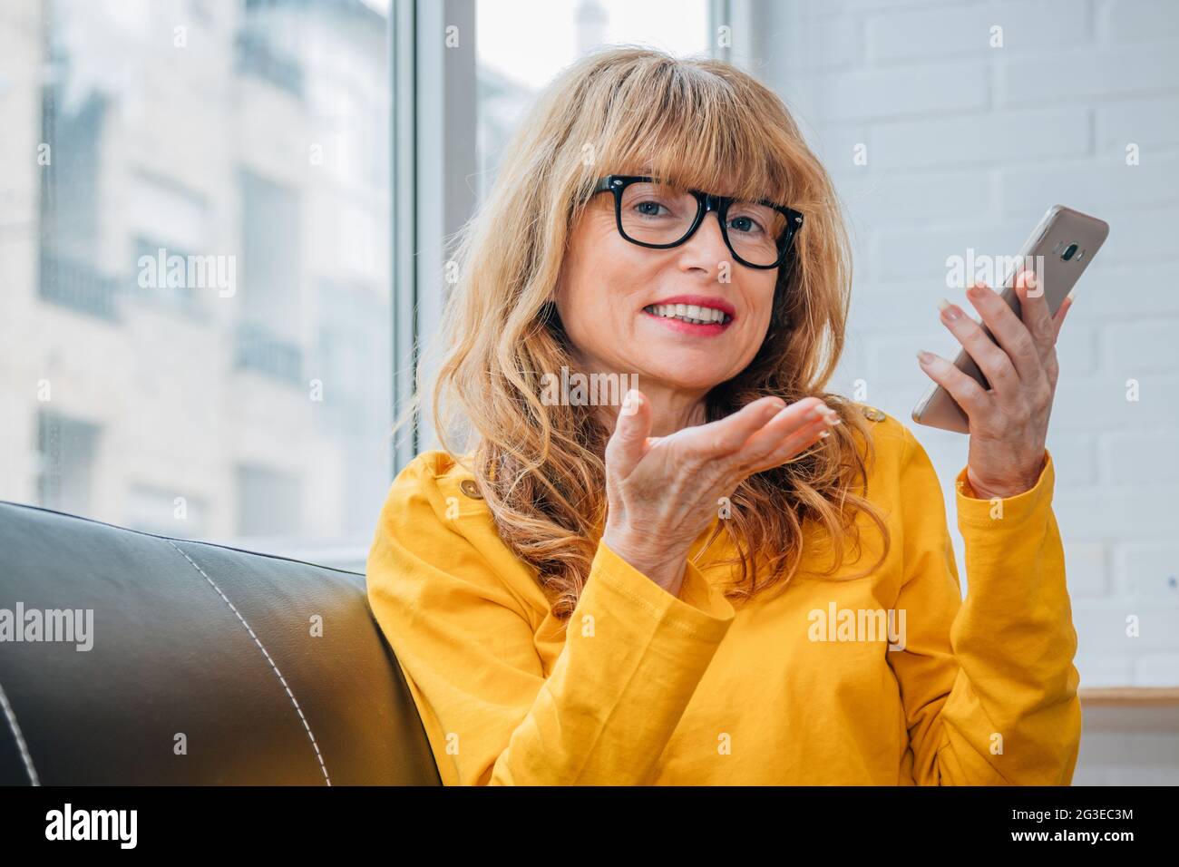 donna che parla al telefono con le mani libere Foto Stock