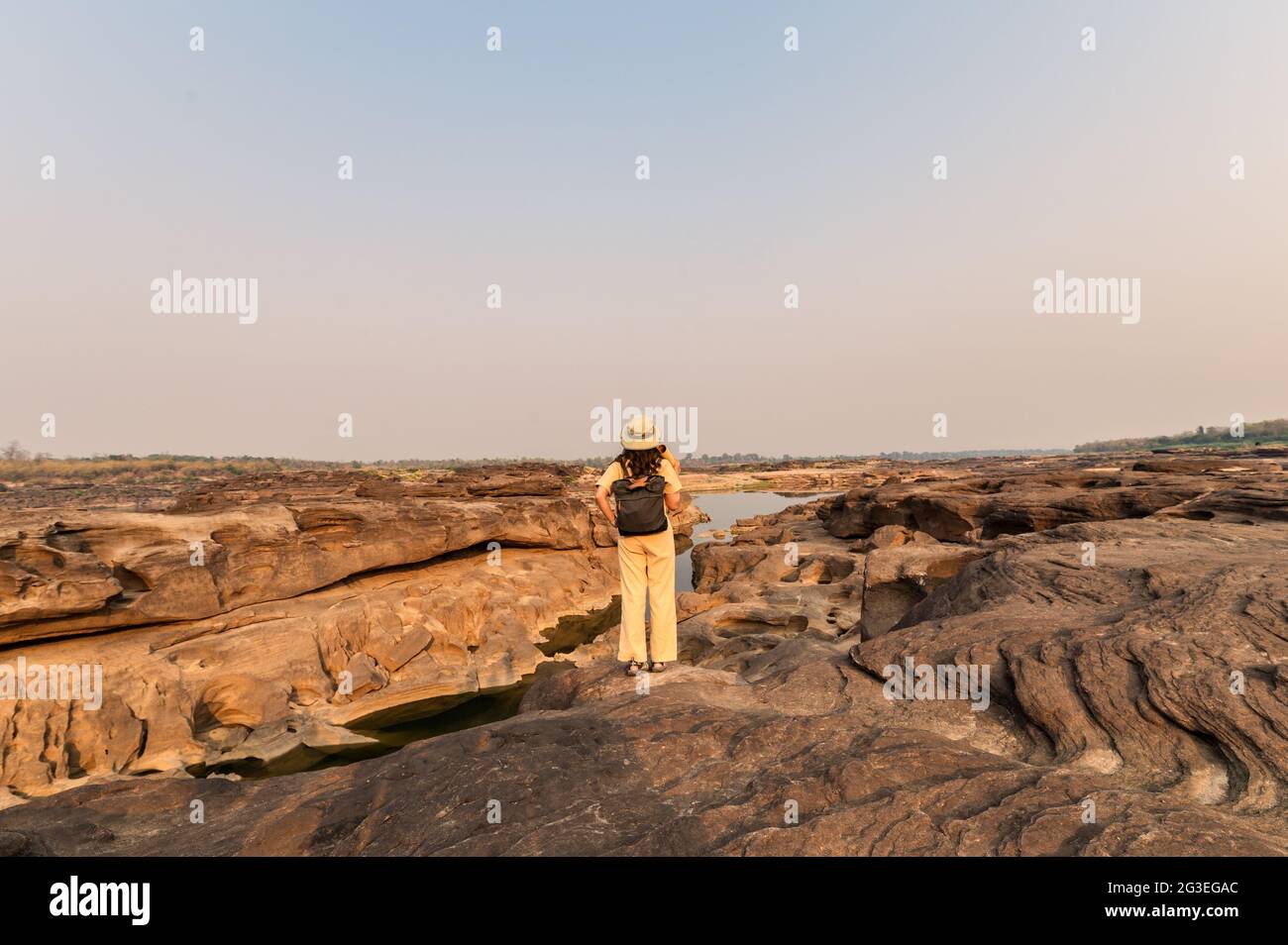 Esploratore asiatico donna in piedi su roccia scogliera con guardare carta mappa in Sam Phan Bok Grand canyon della Thailandia Foto Stock