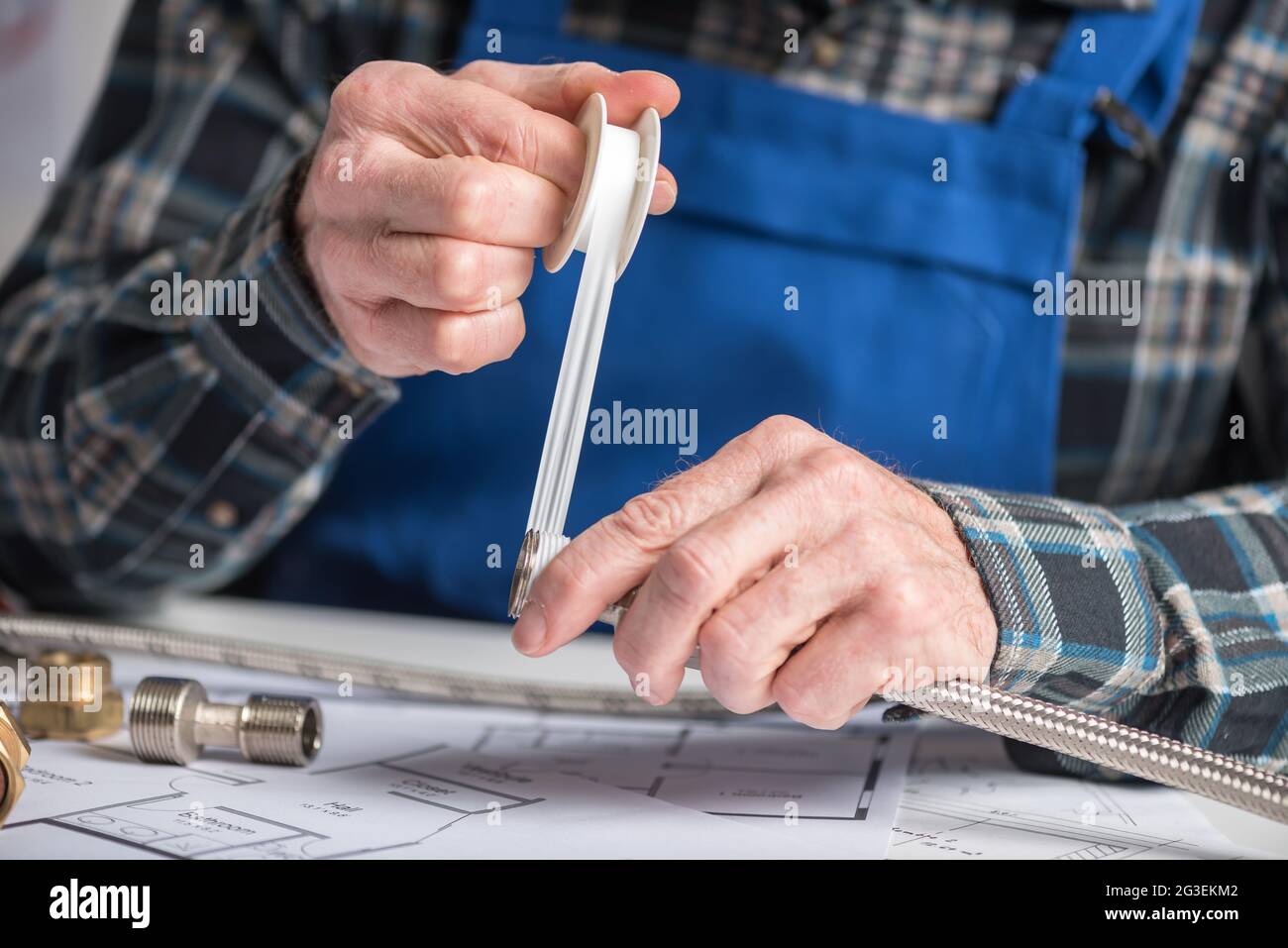 Mani di idraulico che mettono il nastro di teflon su una filettatura di un raccordo idraulico Foto Stock