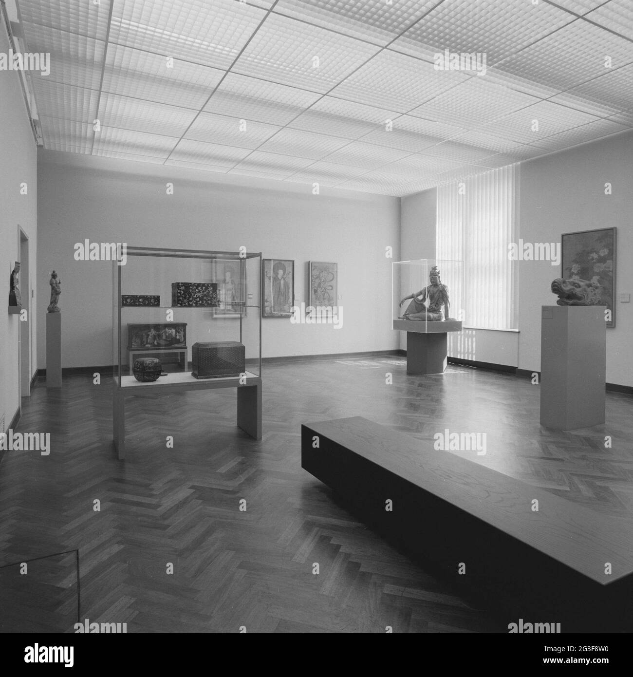 Camera con oggetti in vetrine e immagini su piedistallo; esposizione di arte asiatica attrazione all'apertura (parziale) dopo il rinnovo. Parte posteriore destra dell'immagine Guanyin. Foto Stock