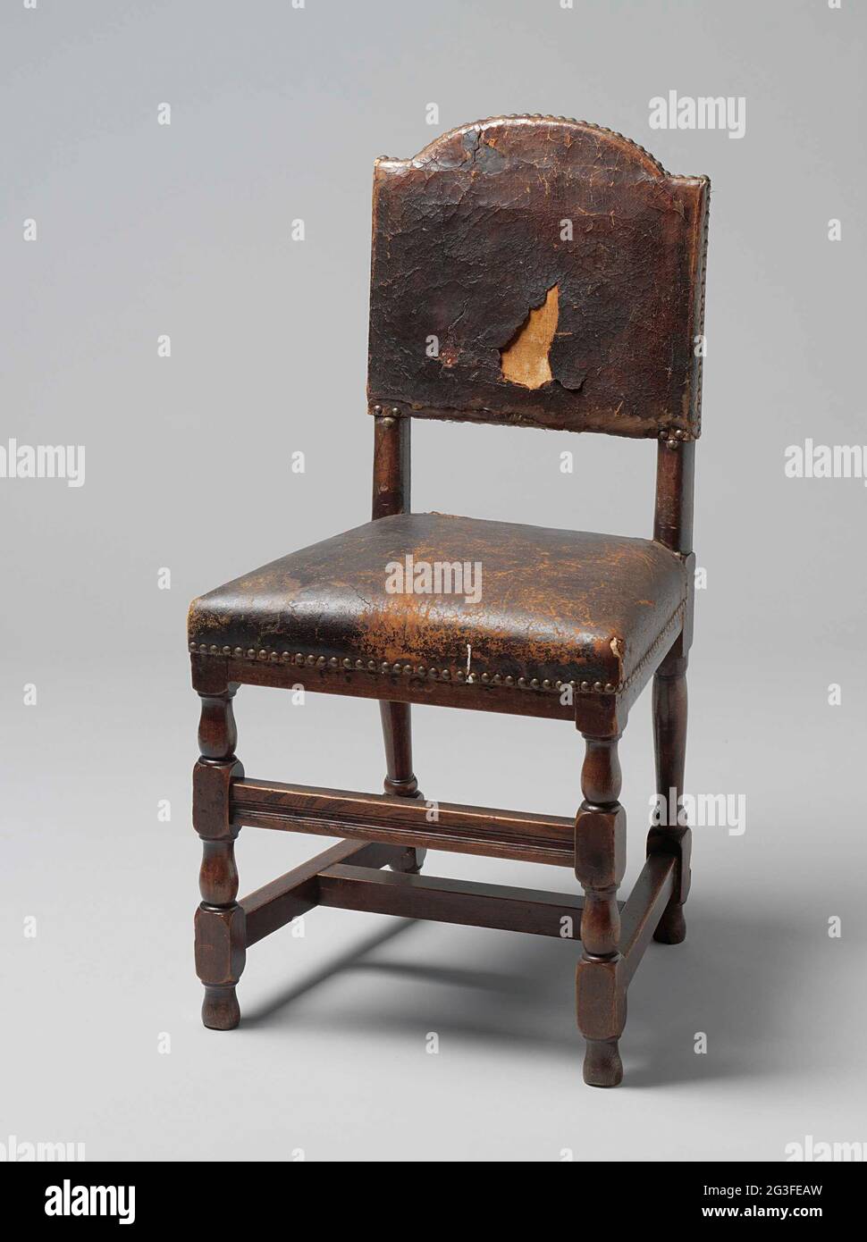 Sedia in rovere con seduta e schienale in pelle. Otto sedie di quercia con seduta e schienale in pelle. Le gambe mostrano a casa e sofferto e sono collegate da una croce a forma di H. C'è un largo anticipo sul fronte, tra due case. Il hind gambe quartiere. Lo schienale poggia in alto sui puntoni ed è piegato dall'alto. Foto Stock